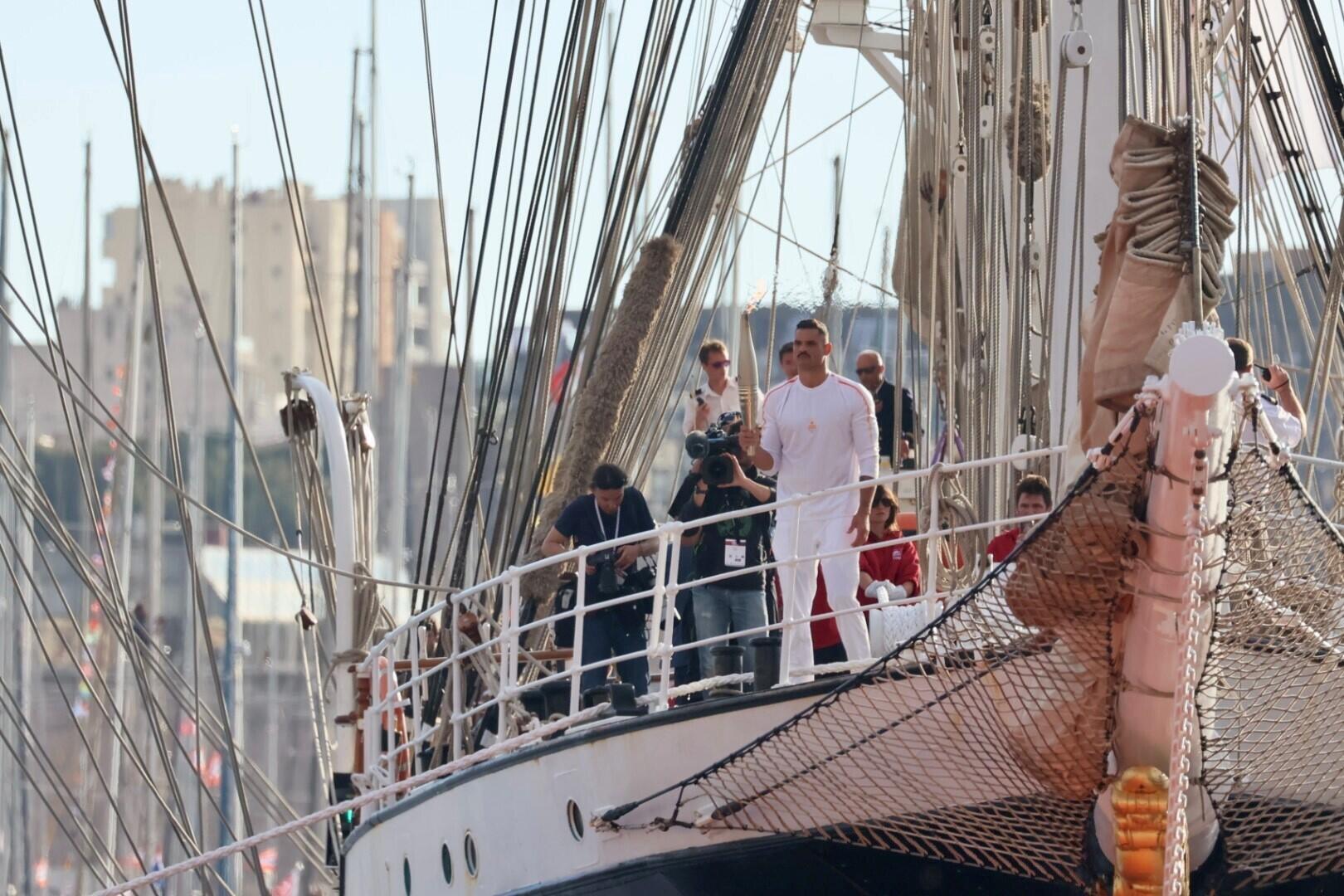 Florent Manaudou sur le « Belem » tenant la flamme olympique lors de son arrivée dans le Vieux-Port de Marseille, le 8 mai 2024.