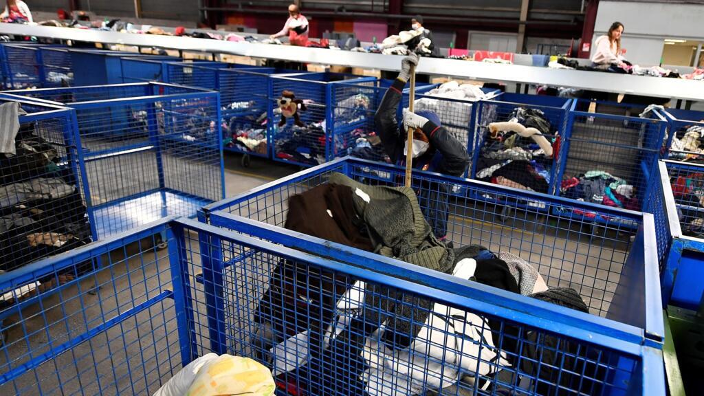 Mulheres separam roupas doadas em um centro de reciclagem Le relais em Bordeaux, no oeste da França, em 23 de janeiro de 2019. Le Relais trata 20 toneladas de roupas de segunda mão por dia e tem 80 funcionários.