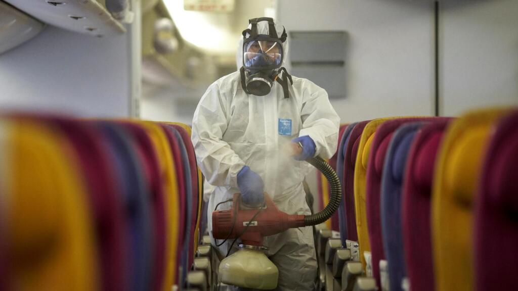 Un membre de Thai Airways procède à la désinfection de la cabine d'un appareil de la compagnie nationale posé sur l'aéroport Suvarnabhumi de Bangkok, le 28 janvier 2020 (photo d'illustration).
