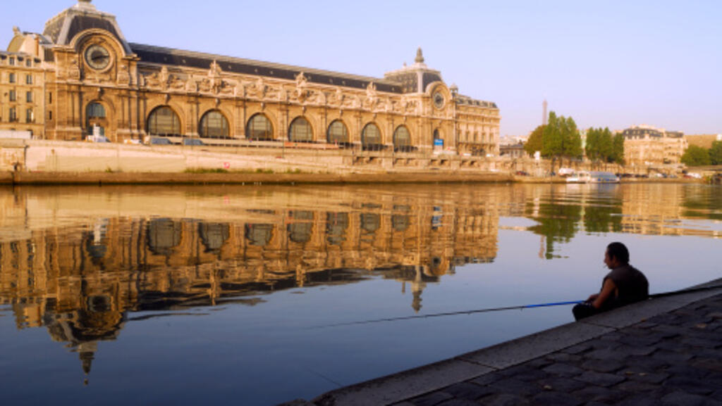 Face au Musée d'Orsay, un pêcheur tente d'attraper un poisson avec sa canne...