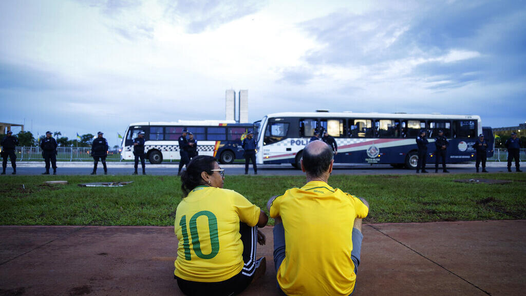 Um casal de apoiadores do ex-presidente Jair Bolsonaro observa a Polícia Militar durante a tentativa de realizar um protesto em Brasília, na quarta-feira, 11 de janeiro de 2023.