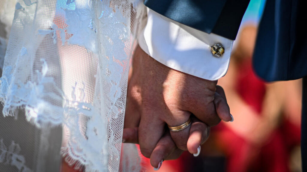 n this photograph taken on August 13, 2022 a newlywed couple hold hands during their secular wedding in Bergheim, eastern France.
