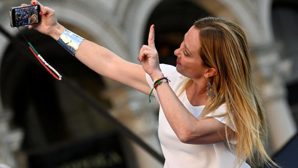 Giorgia Meloni, líder do partido Fratelli, de extrema-direita da Itália, faz uma selfie durante um comício na praça Duomo, antes das eleições de 25 de setembro, em Milão, Itália, em 11 de setembro de 2022.