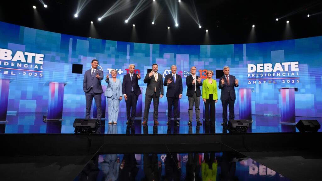 De gauche à droite, les candidats à la présidence Franco Parisi du Parti du peuple, Jeannette Jara de la coalition Unidad por Chile, Marco Enriquez-Ominami du Parti progressiste, Johannes Kaiser du Parti national libertaire, José Antonio Kast du Parti républicain, Eduardo Artes du Parti d'action prolétarienne, Evelyn Matthei de la coalition Chile Vamos et Harold Mayne-Nicholls, candidat indépendant, font un geste avant un débat en vue des élections générales de novembre, à Santiago, au Chili, le lundi 10 novembre 2025.