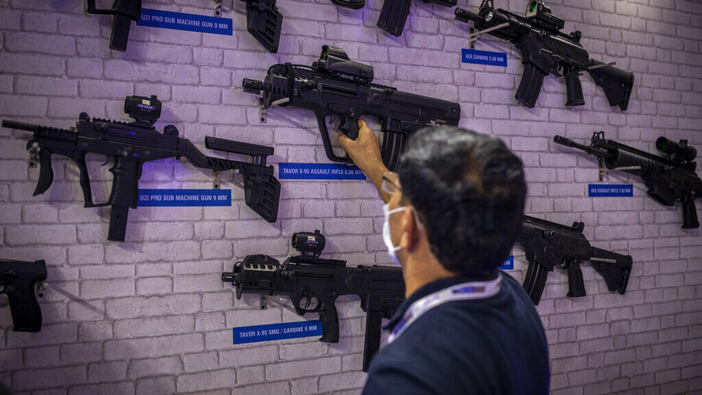 Um expositor arruma armas fabricadas pela PLR Systems Private Limited, uma joint-venture entre o Adani Group, da Índia, e a Israel Weapon Industries (IWI), de Israel, na International Police Expo 2021 em Nova Déli, Índia, em 18 de agosto de 2021.