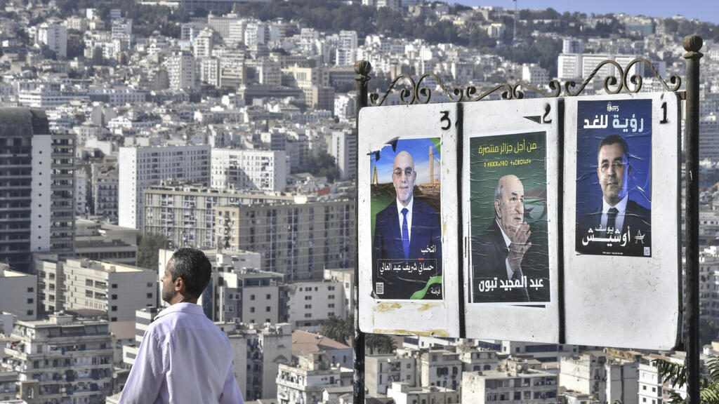 Un homme passe devant des affiches électorales des candidats à la présidentielle, dont le président Abdelmadjid Tebboune, au centre, mardi 27 août 2024, à Alger, en Algérie.