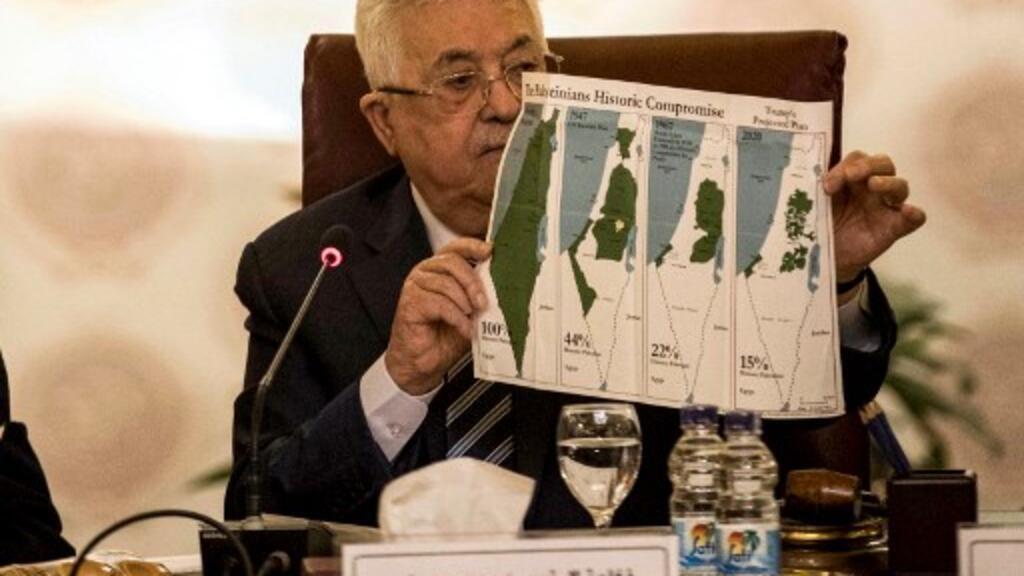 Le président de l'Autorité palestinienne Mahmoud Abbas montre différentes cartes de la Palestine: le plan de partition de l'ONU de 1947, les frontières de 1948-67 et une carte sans les zones annexées par Israël, au Caire, le 1er février 2020.