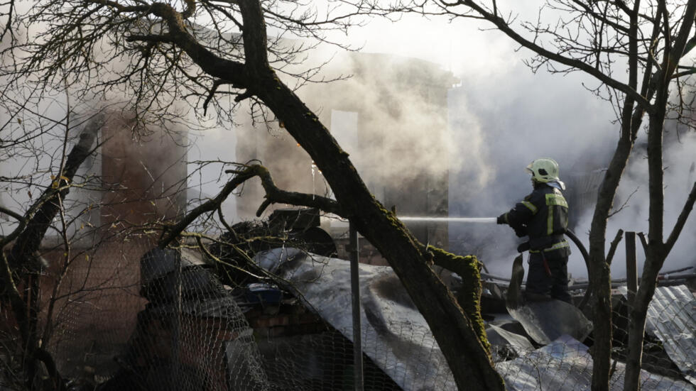 Equipes de socorro trabalham para apagar um incêndio em uma casa após um ataque de drone em Stanovoye, região de Moscou, em 10 de novembro de 2024.