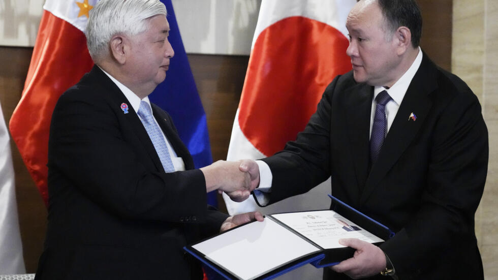 Philippine Defense Secretary Gilberto Teodoro, right, shakes hands with Japanese Defense Minister Gen Nakatani after signing the guestbook in Makati city, Philippines on Monday, Feb. 24, 2025