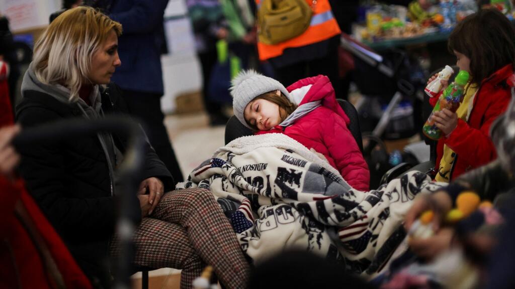Un enfant dort dans un lieu d'accueil temporaire après que des réfugiés ont fui l'Ukraine pour Bucarest, en Roumanie, le 13 mars 2022.