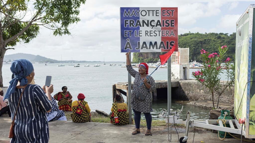 Une femme pointe son doigt vers une pancarte sur laquelle on peut lire : « Mayotte est française et le restera à jamais », lors d'un rassemblement à Mamoudzou sur l'île de Mayotte, le 29 avril 2023.