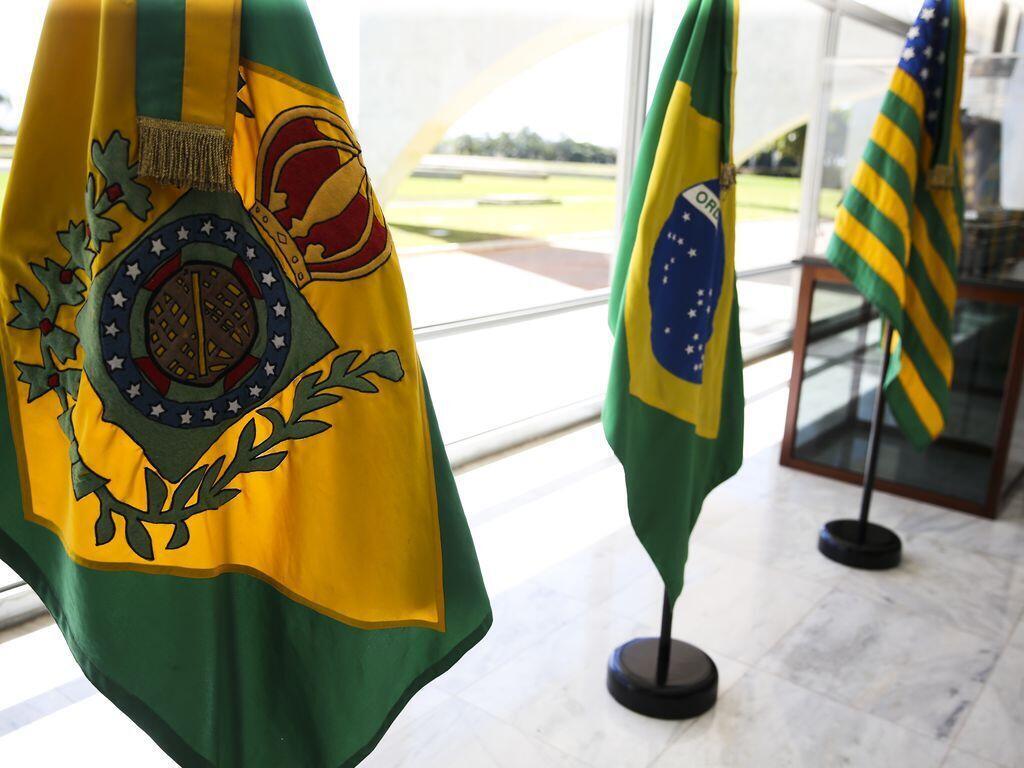 Em primeiro plano, a Bandeira Imperial do Brasil, seguida pela Bandeira em vigor e ao fundo, Bandeira provisória da República.