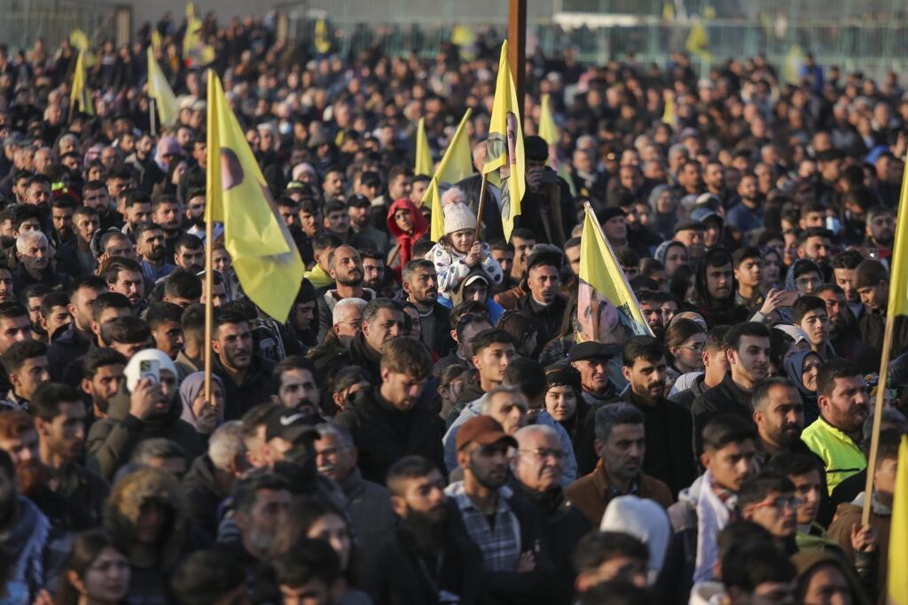 Une foule regarde les membres d'une délégation pro-kurde du Parti pour l'égalité et la démocratie des peuples publier une déclaration du chef emprisonné du PKK, Abdullah Öcalan, à Qamishli, dans le nord-est de la Syrie, le jeudi 27 février 2025.