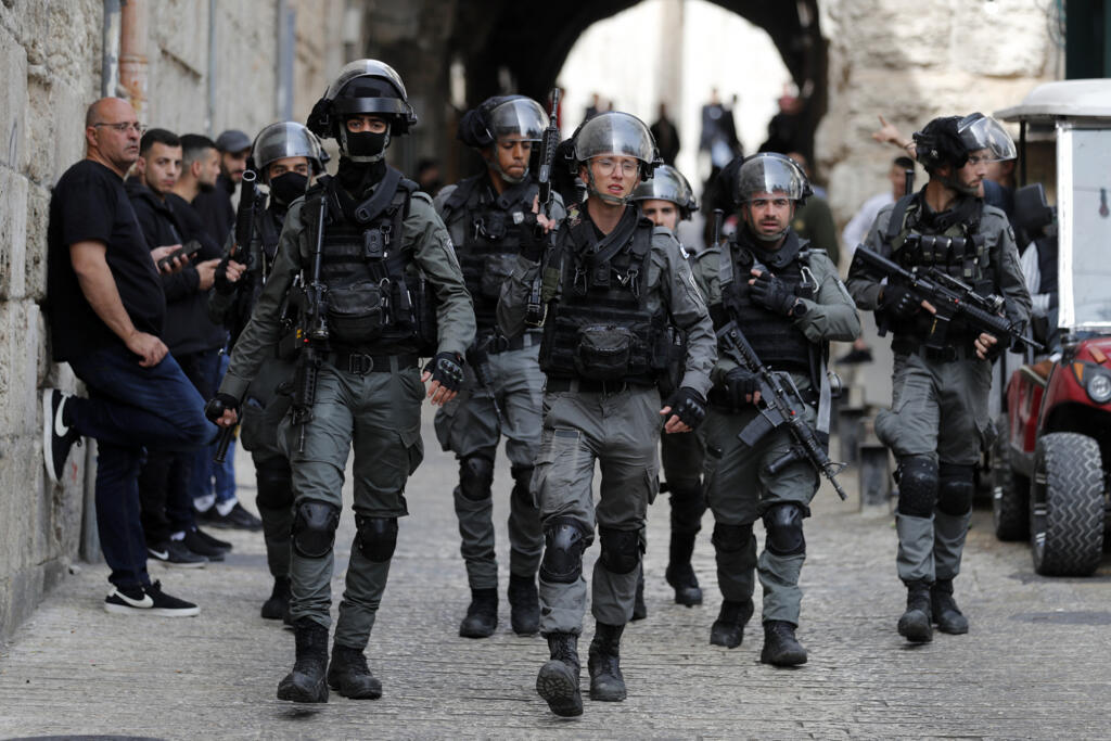 A polícia de fronteira israelense faz patrulha no Portão dos Leões, na cidade velha de Jerusalém, enquanto palestinos esperam a liberação para entrar na Mesquita de Al-Aqsa, domingo, 17 de abril de 2022.