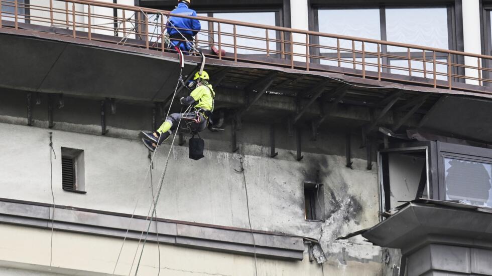 Municipal workers investigate the place after a downed Ukrainian drone damaged a building in western Moscow, Russia, Friday, March 14, 2025.