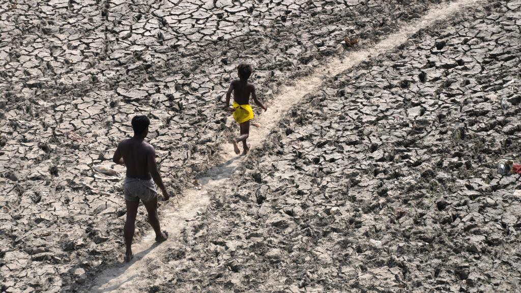 Des habitants marchent à travers la rivière Yamuna asséchée, suite à une vague de chaleur extrême à New Delhi, le 2 mai 2022. Selon une nouvelle étude, les Indiens pourraient être les plus impactés par les températures extrêmes du changement climatique. (Image d'illustration)