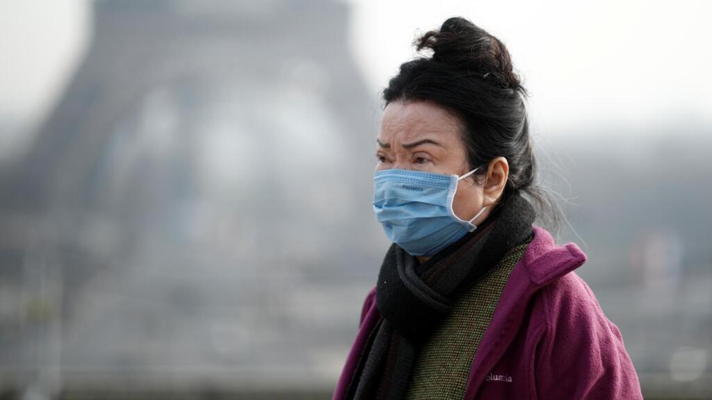 Une femme porte un masque facial sur l'esplanade du Trocadéro en face de la Tour Eiffel à Paris, France, le 25 janvier 2020, alors que la France a confirmé trois cas de nouveau coronavirus.
