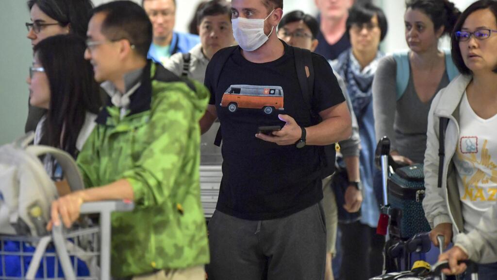 Un passager, portant un masque par mesure de précaution pour éviter de contracter le virus Covid-19, traverse l'aéroport international de Guarulhos, à Guarulhos, Sao Paulo, Brésil le 26 février 2020.