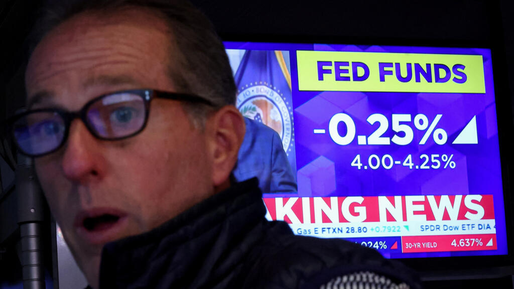 A specialist trader reacts, as a screen displays the Fed rate announcement on the floor of the New York Stock Exchange (NYSE) in New York City, U.S., September 17, 2025.