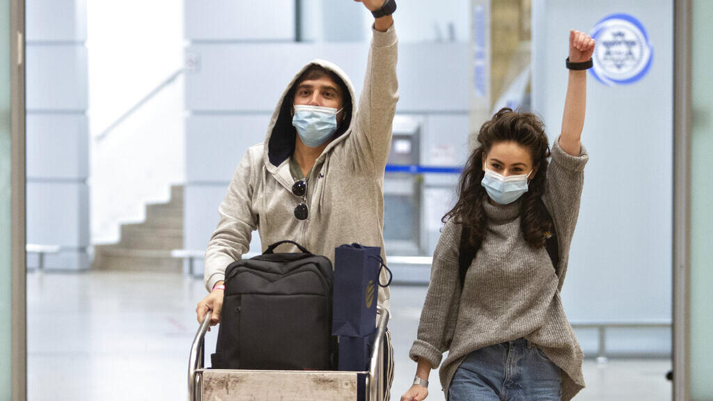 Os viajantes israelenses exibem as pulseiras eletrônicas de monitoramento que devem usar após retornarem do exterior, no aeroporto Ben-Gurion, perto de Tel Aviv, Israel, na segunda-feira, 1º de março de 2021.