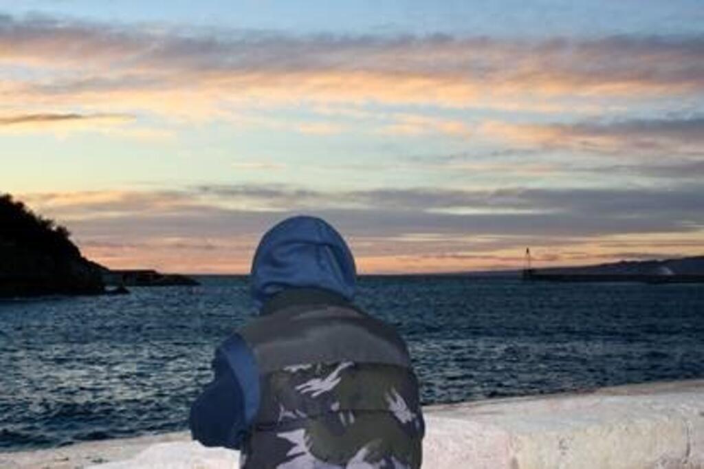 Un jeune garçon regarde la mer depuis le Vieux-Port de Marseille : « La nuit, sur l'embarcation en plein milieu de l'eau, c'était tout noir. »