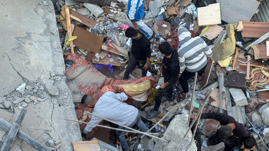 Des habitants fouillent une maison détruite par une frappe à Khan Younès, vendredi 1er décembre 2023.