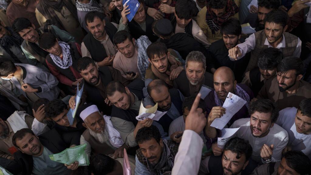 Des Afghans rassemblés devant un bureau des passeports du gouvernement récemment rouvert, à Kaboul, le mercredi 6 octobre 2021.