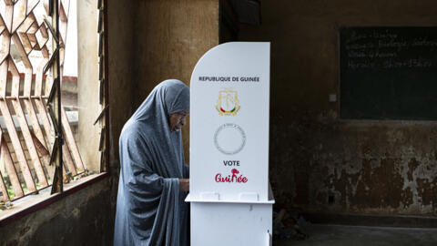 A voter marks her ballot behind a voting booth at Hamdallaye Primary School polling station in Conakry on 21 September, 2025 as Guinea votes in the constitutional referendum. 
