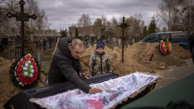 Vova, 10 ans, avec son père devant le corps de sa mère, Maryna, près de Kiev, .