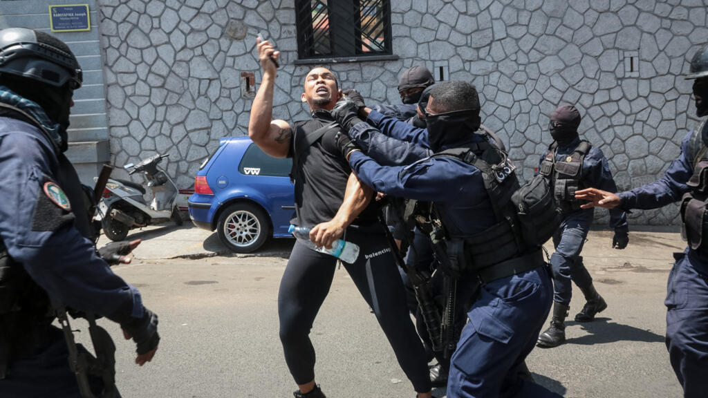 Un manifestant est appréhendé par des policiers alors qu'il manifeste contre les coupures répétées d'eau et d'électricité à Antananarivo, le 25 septembre 2025.