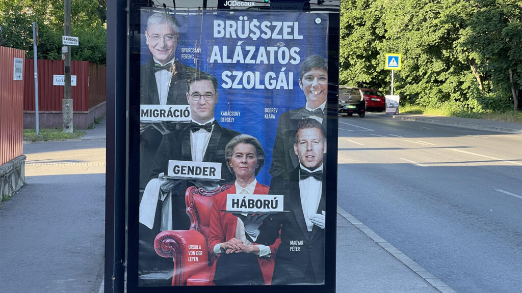 Affiche électorale du Fidesz : Ursula von der Leyen, présidente de la Commission européenne, entourée de ses « humbles serviteurs », les figures de l’opposition hongroises qui portent sur des plateaux les mots « immigration », « genre » et « guerre ».