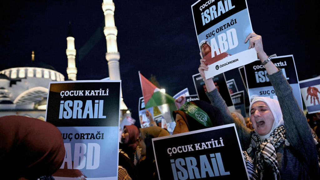 Demonstrators hold placards reading as they attend a rally in support of Palestinians, outside the Israeli Consulate, in Istanbul on October 18, 2023.