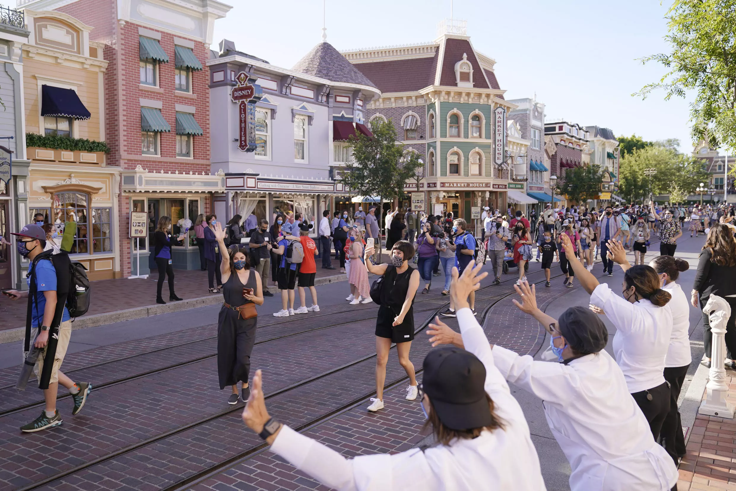 Los visitantes  caminan por Main Street USA en Disneylandia en Anaheim, California, el viernes 30 de abril de 2021. El icónico parque temático del sur de California que estaba cerrado bajo las estrictas normas estatales sobre el virus abrió sus puertas el viernes y algunos visitantes entraron animados y gritando de felicidad