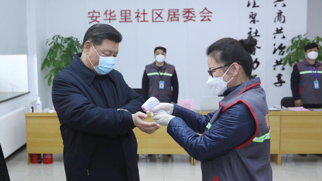 Chinese President Xi Jinping, wearing a face mask has his temperature checked in Beijing