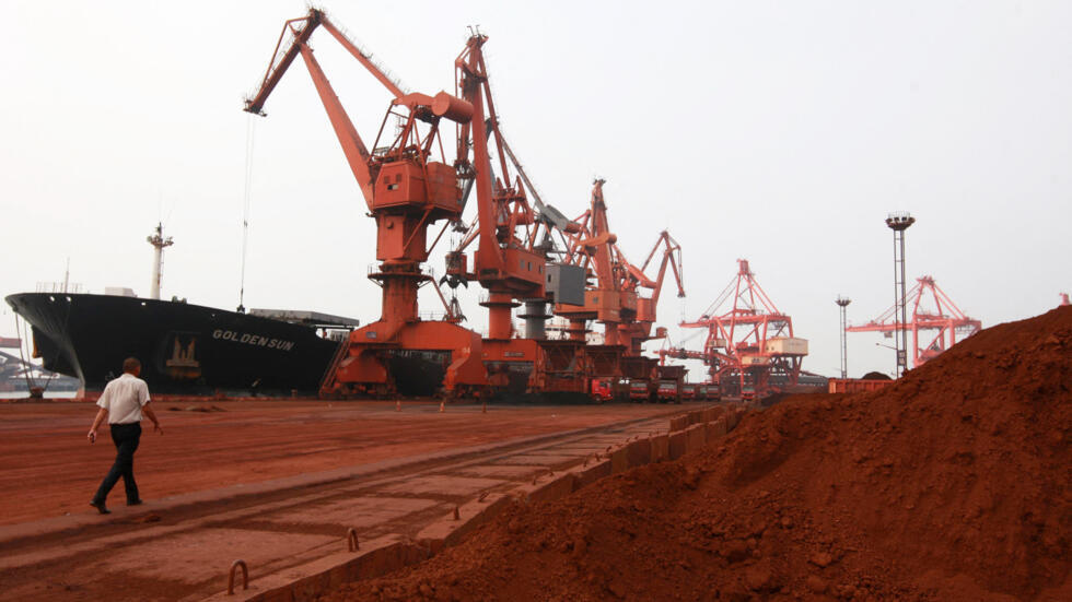 Bulldozer scoop soil containing various rare earth to be loaded on to a ship at a port in Lianyungang, east China's Jiangsu province on September 5, 2010