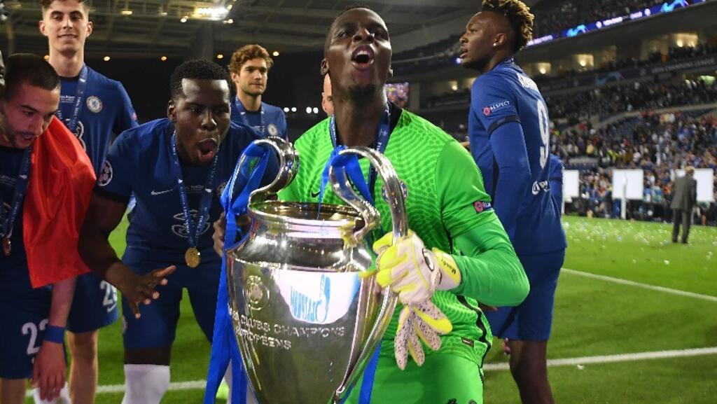 O goleiro senegalês Édouard Mendy levanta a taça da Liga dos Campeões conquistada com o Chelsea contra o Manchester City. Em 29 de maio de 2021.