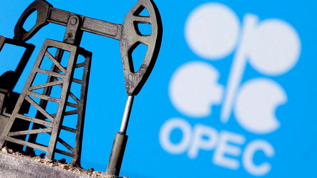 Miniatura de máquina de perfuração de campo petrolífero diante do logo da Opep. Foto ilustrativa.