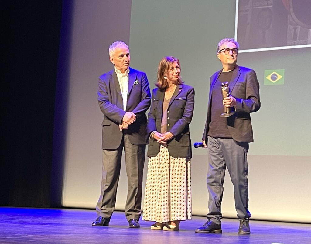 O presidente do Festival de Cinema Latino-Americano de Biarritz, Serge Fohr (e), a prefeita de Biarritz, Maider Arosteguy, e o cineasta pernambucano Kleber Mendonça Filho na cerimônia de entrega do prêmio "Abraço de Honra". Em Biarritz, em 20 de setembro de 2025.