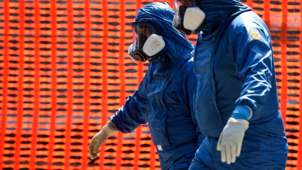 Des spécialistes de l'armée russe sortent de la maison de soins infirmiers Honegger, où 35 personnes sont mortes jusqu'à présent du COVID-19, à Albino, en Lombardie, dans le nord de l'Italie, le 28 mars 2020.