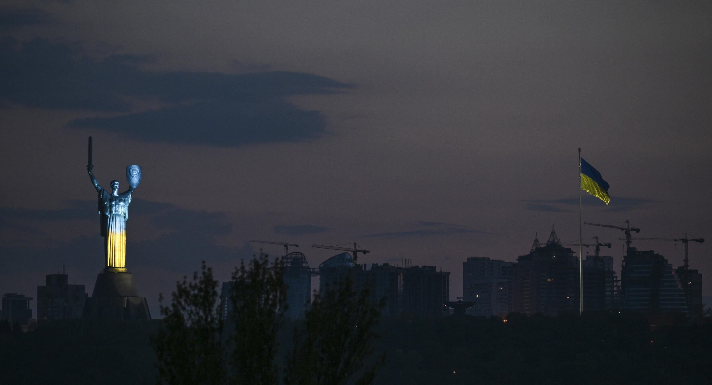 Los colores de la bandera ucraniana son proyectados sobre la estatua de la Madre Patria en un museo de Kiev, el 8 de mayo de 2022