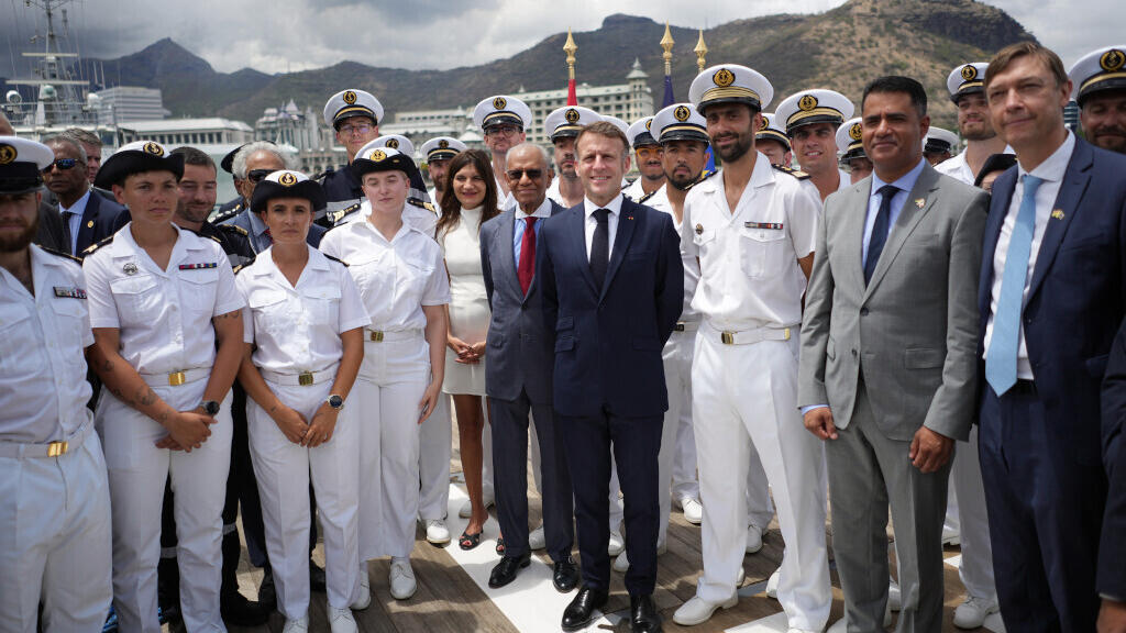 Le président français Emmanuel Macron (à droite) et le Premier ministre mauricien Navin Ramgoolam (au centre) posent pour une photo avec l'équipage du navire Champlain, le vendredi 21 novembre 2025 à Port-Louis, à Maurice.