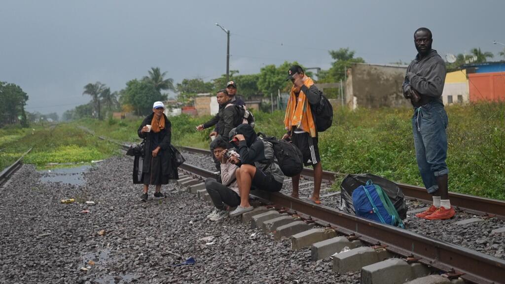 Dans l'État de Veracruz, au Mexique, près des logements des Patronas, des migrants attendent le train pour se hisser à bord.