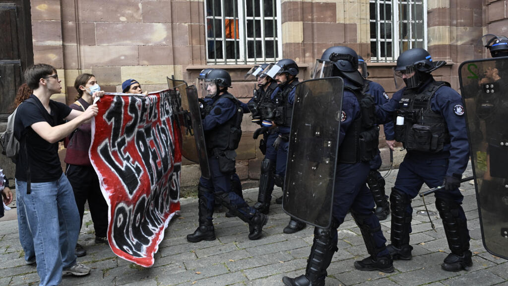 Brandissant une banderole sur laquelle on peut lire «Un héros: le peuple qui bloque tout», des manifestants du mouvement «Block Everything» font face à la police française à Strasbourg, dans l'est de la France, mercredi 10 septembre 2025.