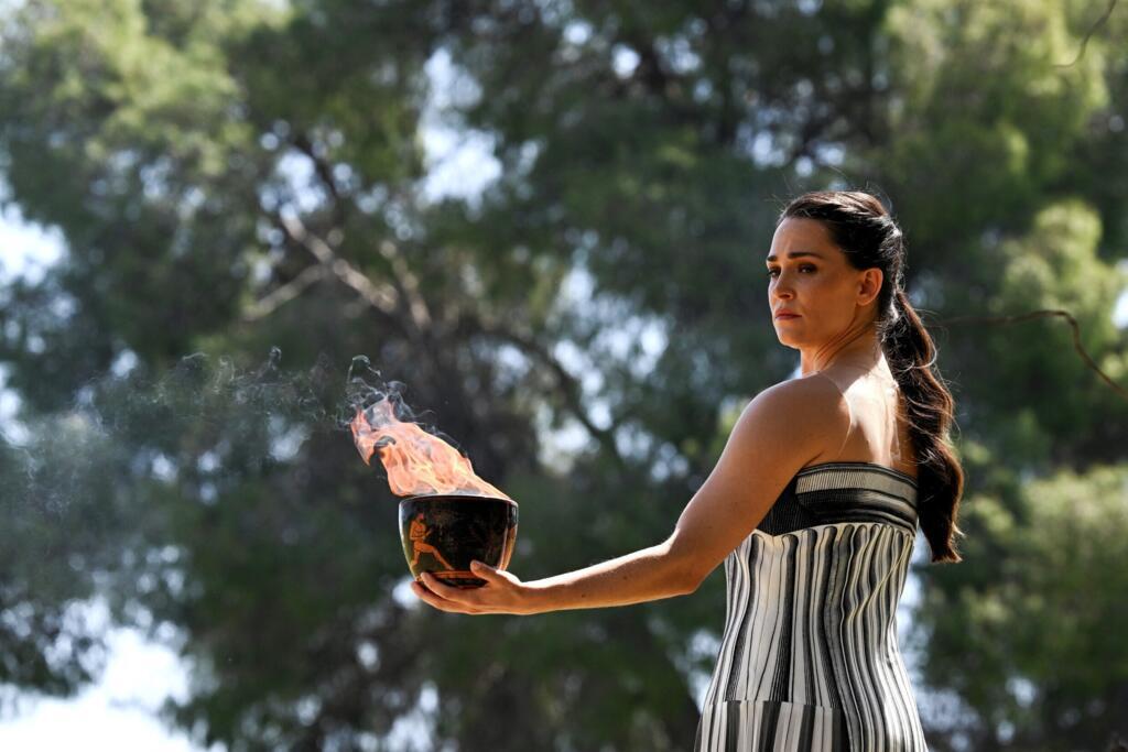 L'actrice grecque Mary Mina, qui joue le rôle de la grande prêtresse, tient la flamme olympique lors de la répétition de la cérémonie d'allumage de la flamme pour les Jeux olympiques de Paris 2024 au temple antique d'Héra sur le site archéologique d'Olympie, berceau des Jeux olympiques antiques dans le sud de la Grèce, le 15 avril 2024.