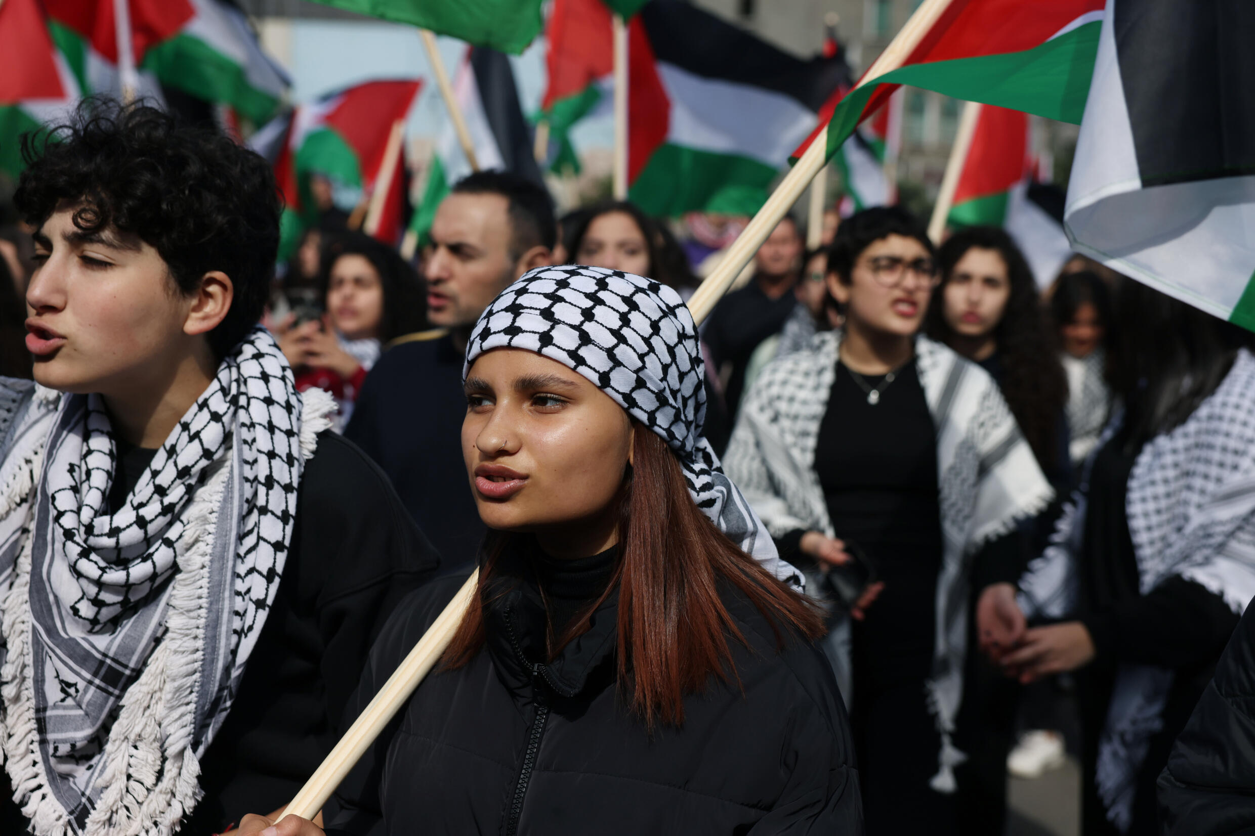 Una mujer ondea una bandera palestina y luce el tradicional pañuelo kefia en una marcha por el Día de la Tierra en la ciudad árabe-israelí de Sajnin, el 30 de marzo de 2023