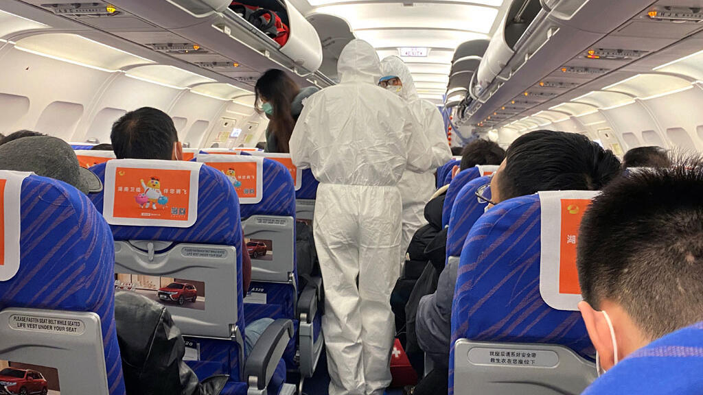 Des agents de santé en tenue de protection vérifient l'état d'un passager dans un avion qui vient d'atterrir de Changsha, ville d'une province voisine du centre de l'épidémie de coronavirus de la province du Hubei, à Shanghai le 25-01-2020.