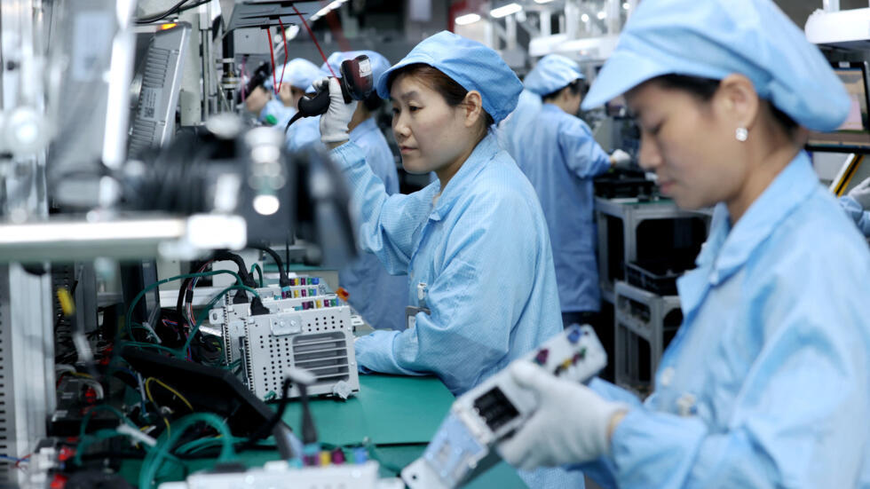 Workers work on a production line manufacturing smart automotive central control navigation products at a factory of Beidou Intelligent Connected Vehicle Technology Co. (BICV) in the High Tech Industr