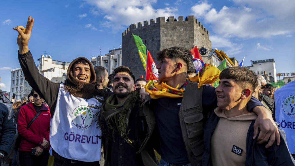 People gather to watch live on a tv screen a Pro-Kurdish Peoples' Equality and Democracy Party, or DEM, delegation members releasing an statement from the jailed leader of the rebel Kurdistan Workers' Party, or PKK, Abdullah Ocalan, in Diyarbakir, Turkey, Thursday, Feb. 27, 2025. (AP Photo/Metin Yoksu)